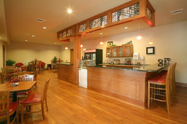 A cozy restaurant interior featuring a wooden bar and dining area.