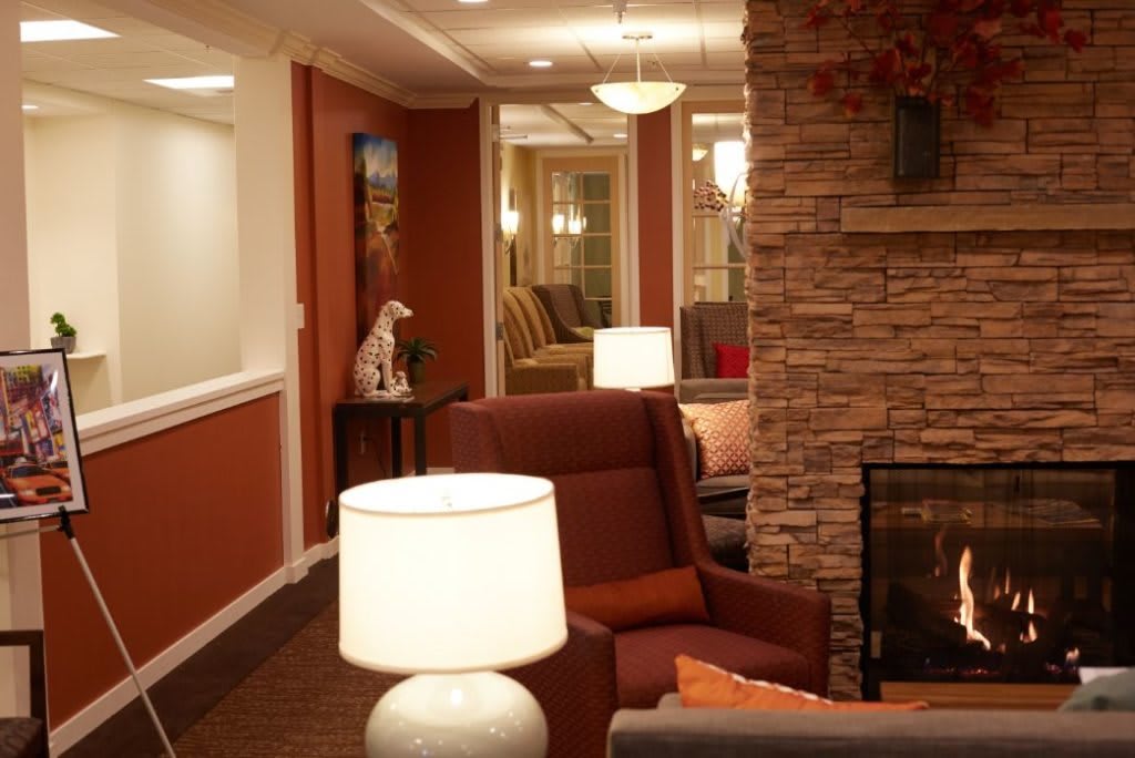 A cozy living room interior with comfortable seating, warm lighting, and a stone accent wall.
