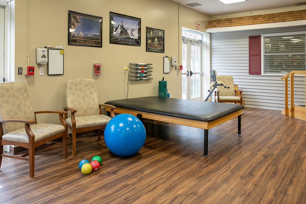 A physical therapy room equipped with a treatment table and exercise balls.