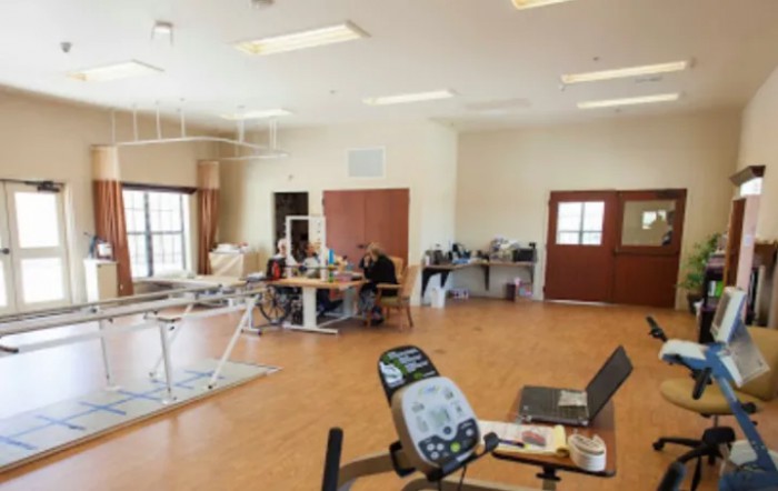 A rehabilitation room equipped with various exercise machines and therapy equipment.