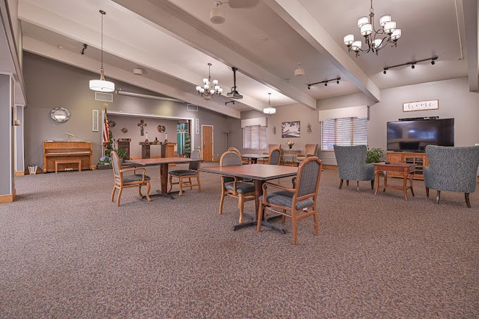 A spacious dining area with several tables and chairs, featuring large windows and elegant lighting fixtures.