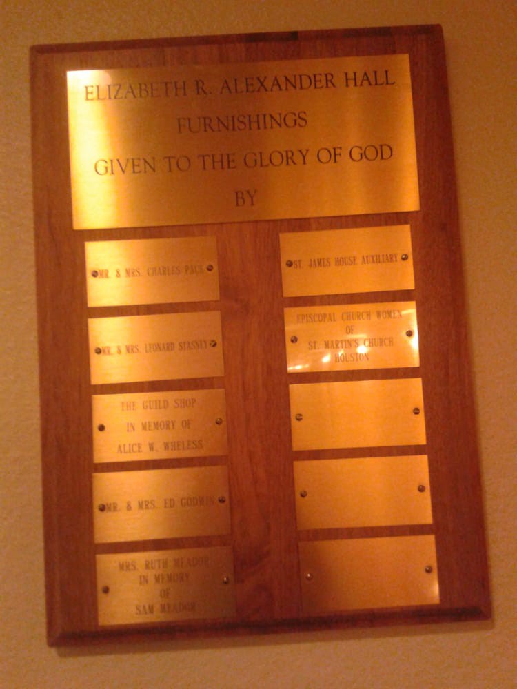 A wooden plaque with engraved golden plates, listing names as part of an award or recognition display.