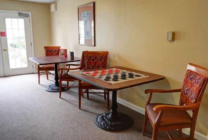 A cozy indoor setting featuring tables and chairs, one with a checkerboard design.