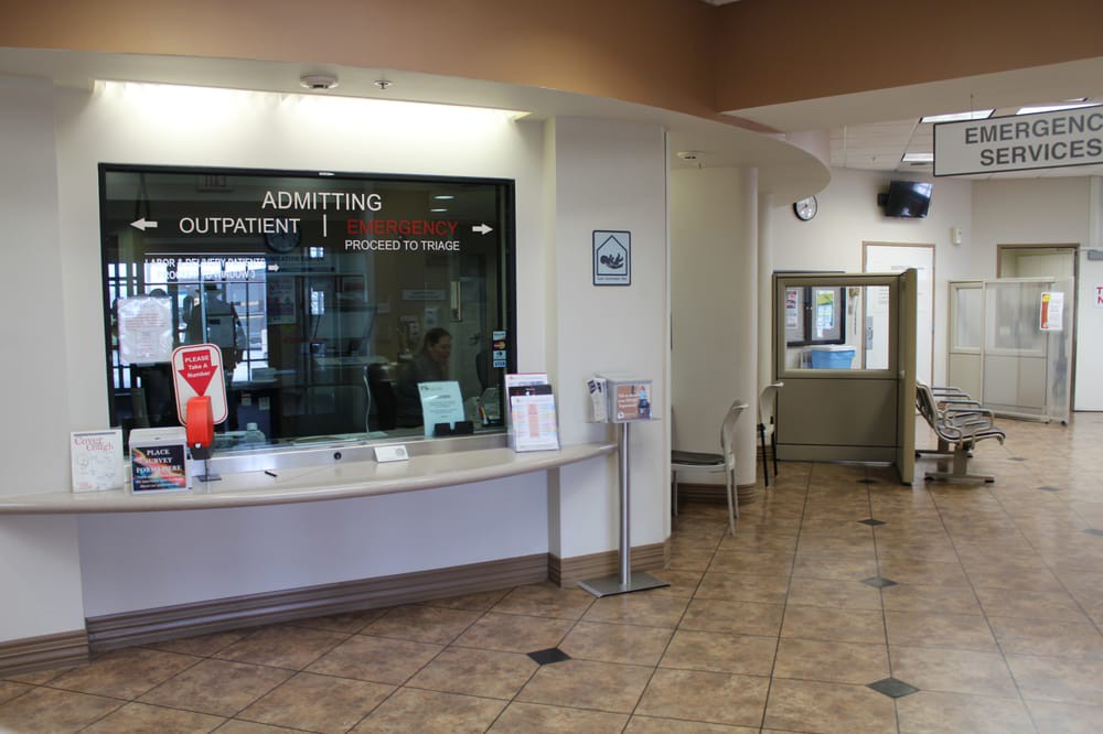 A hospital reception area with an admitting counter and a waiting room.