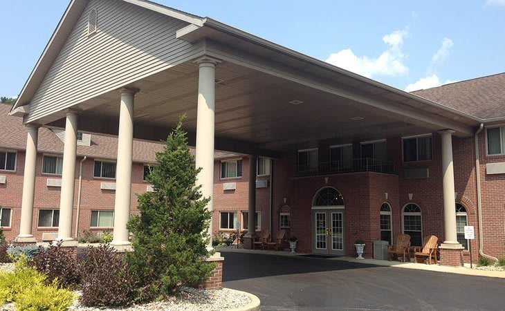 The entrance of a brick building with a large canopy supported by columns.