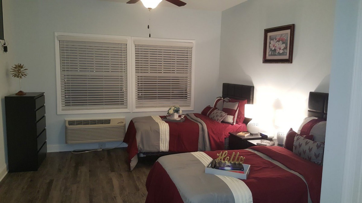 A cozy bedroom with two neatly made twin beds and soft lighting.