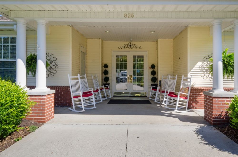 A welcoming entrance with rocking chairs lined up on a front porch.