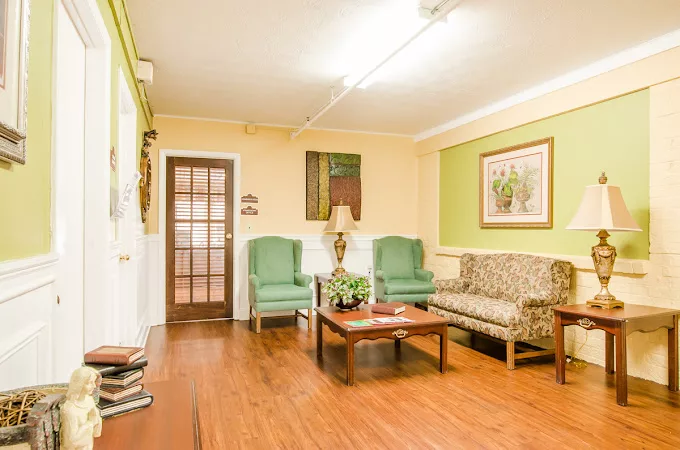 A cozy living room with armchairs and a sofa, complemented by a coffee table on a wooden floor.