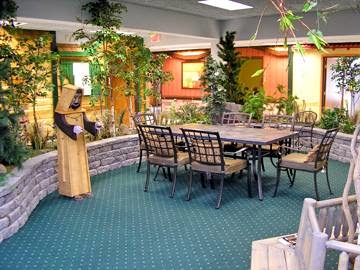 A cozy dining area featuring a table surrounded by chairs, complemented by indoor plants and decorative elements.