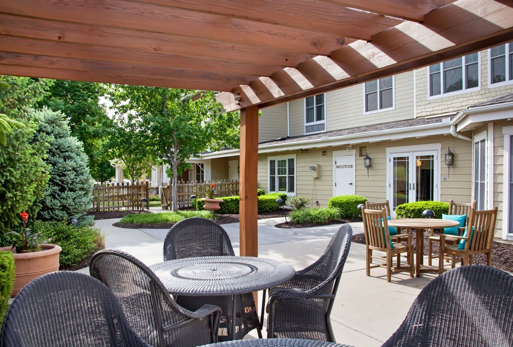 A peaceful outdoor patio with seating under a wooden pergola.