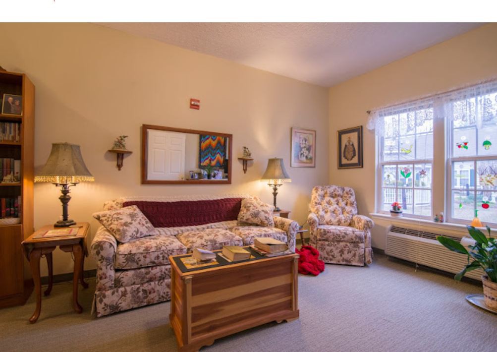 A cozy living room with floral furniture and warm lighting.