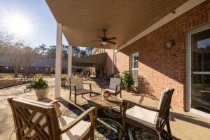 A cozy outdoor patio with comfortable seating under a covered area on a sunny day.