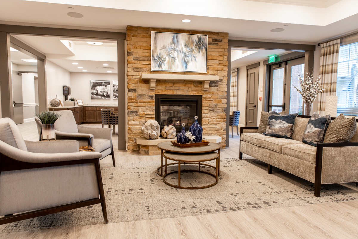 A modern and cozy living room with a stone fireplace and comfortable seating arrangements.