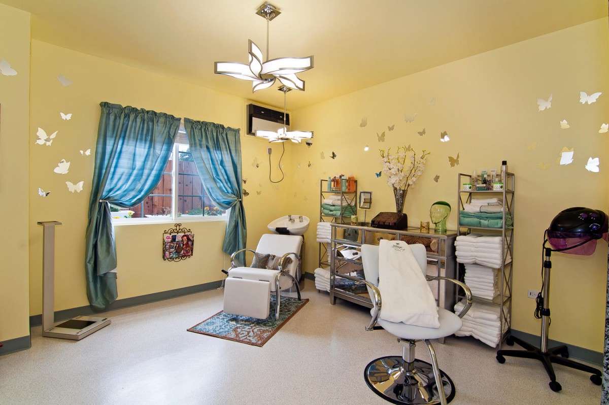 A brightly decorated beauty salon interior with chairs and mirrors.