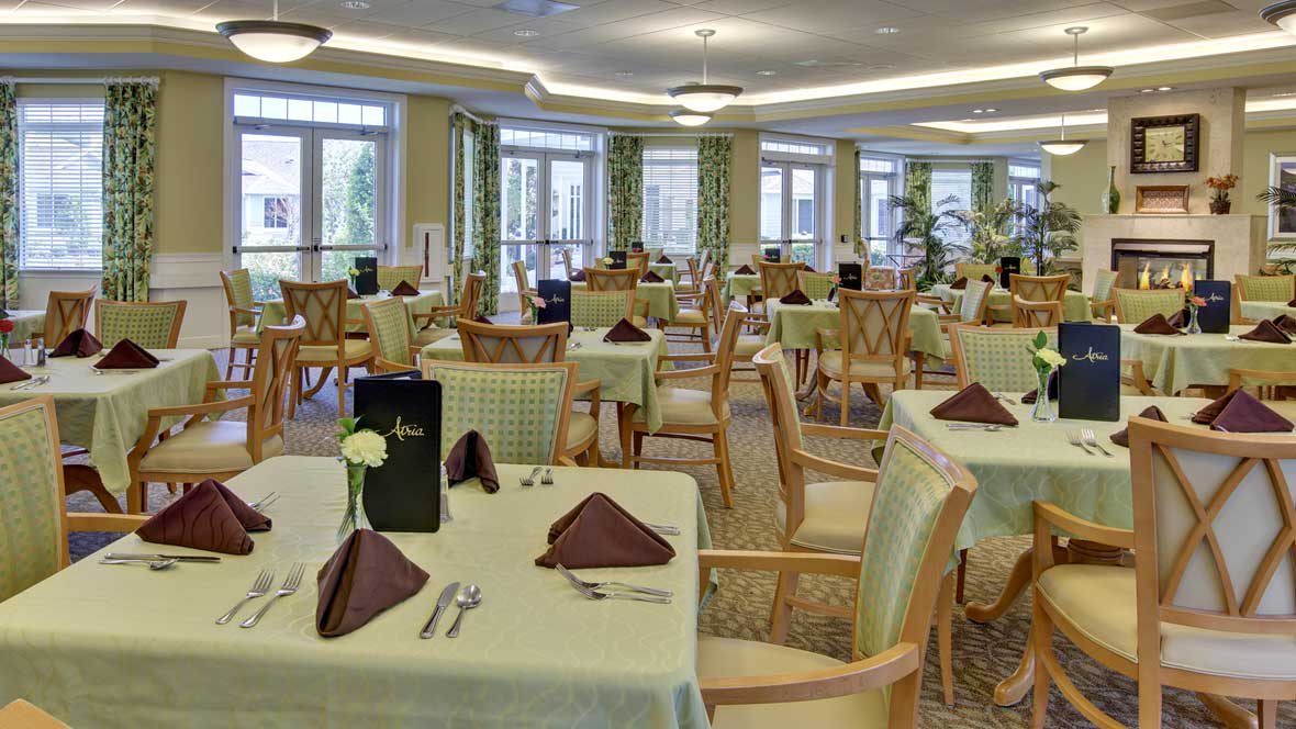 An elegant dining room with neatly arranged tables and chairs.