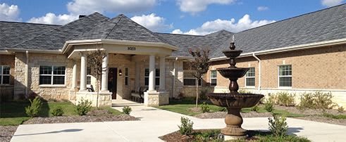 A well-maintained residential house with a fountain at the entrance.