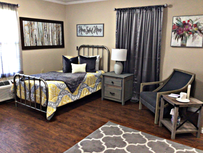 Cozy bedroom with a metal bed frame, patterned bedding, and complementing decor.
