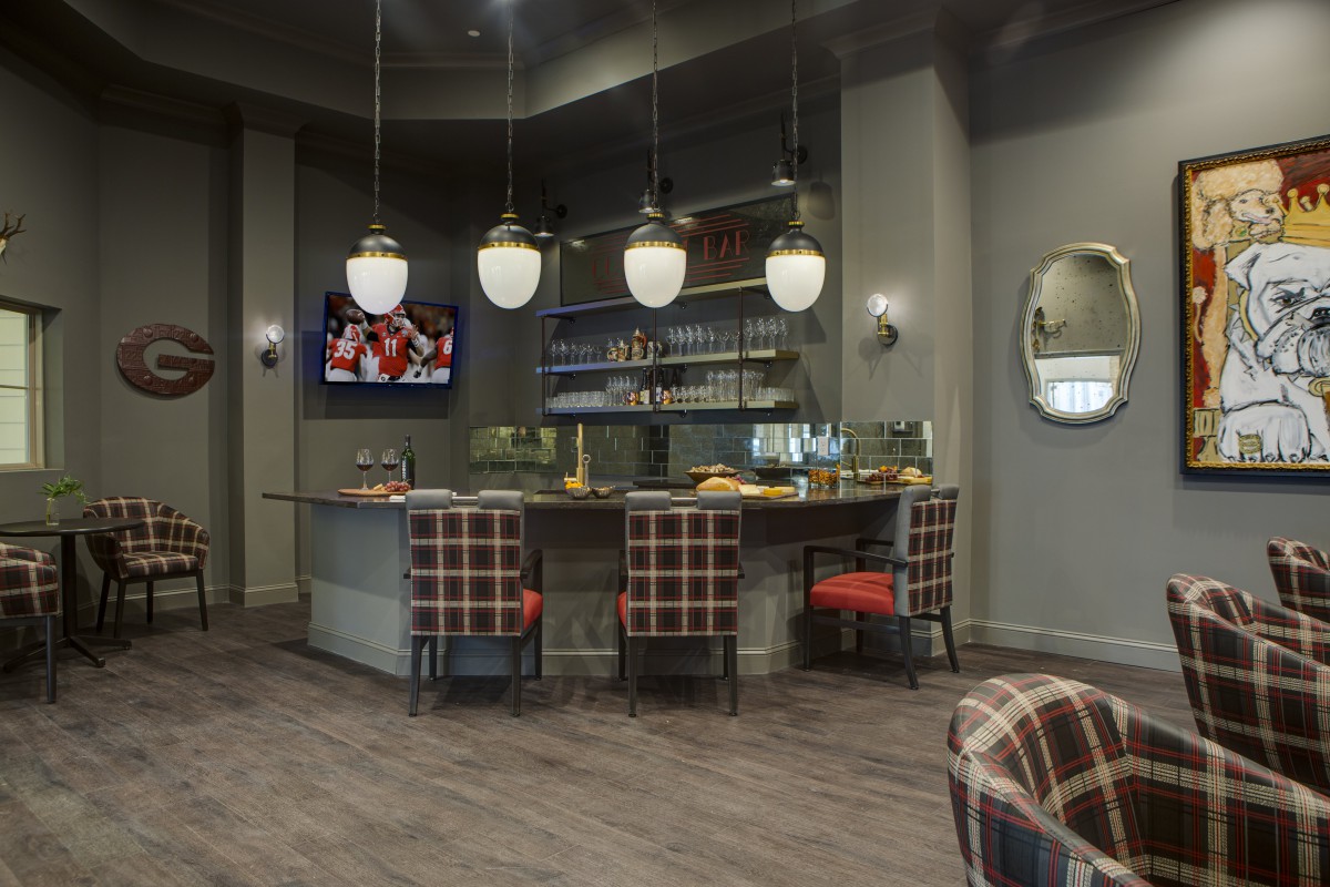 A modern bar with plaid armchairs, pendant lighting, and a sleek, contemporary design.