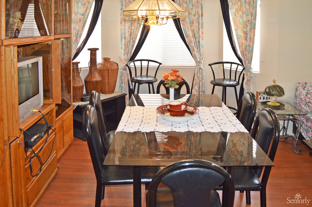 A cozy dining room with a stylish table and chairs, adorned with decorative vases and elegant curtains.