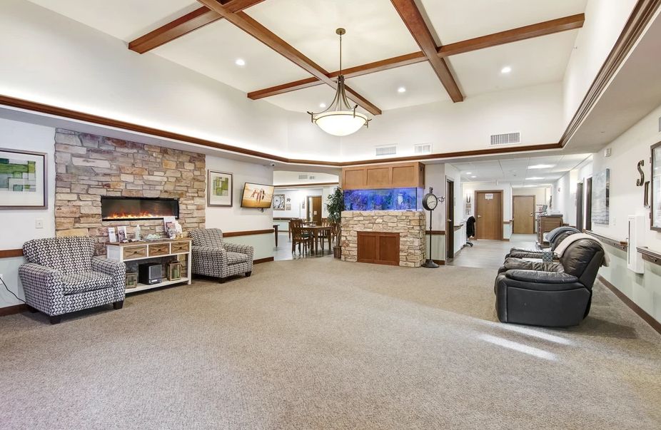 A modern lobby with comfortable seating, a fireplace, and stylish wood beam ceiling.