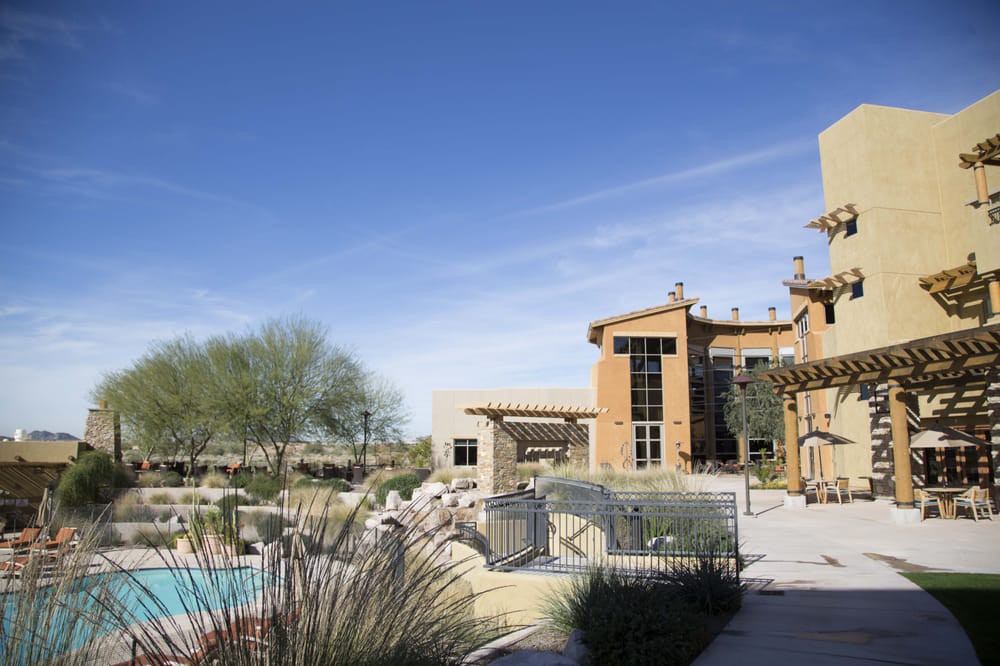 A luxurious resort with a pool set in a desert landscape.