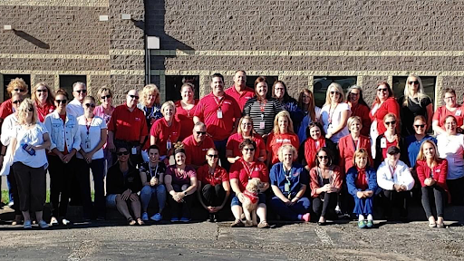 A vibrant group of individuals united in red, showcasing team spirit at a community event.