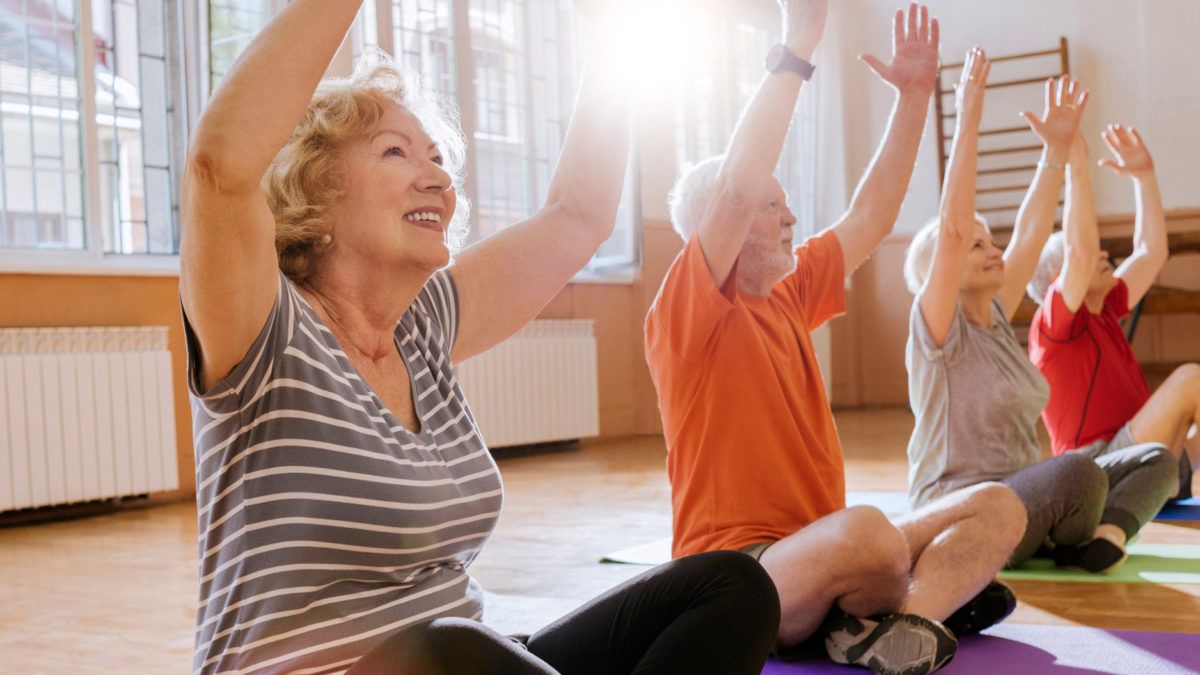 A group of seniors enjoying a yoga session indoors.