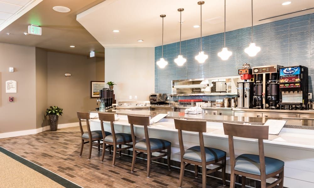 A modern restaurant interior featuring a bar counter with seating and stylish lighting.