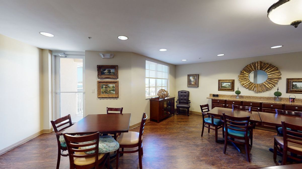 A cozy dining area with tables, chairs, and wall art.