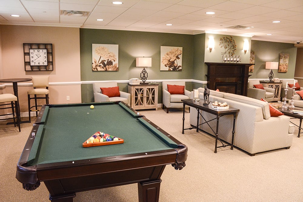 A cozy game room featuring a pool table, comfortable seating, and stylish decor.