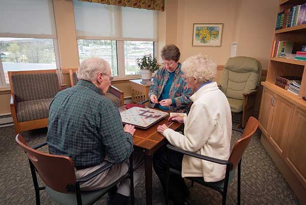 A group of seniors engaging in a leisure activity indoors, enjoying each other's company.