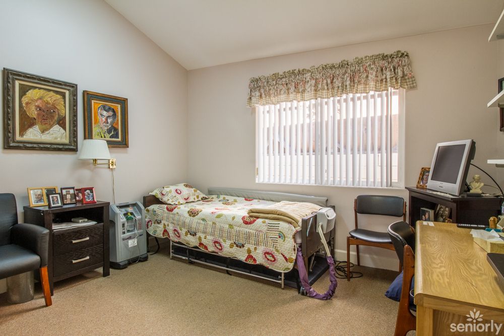 A cozy bedroom with a single bed, adorned with floral bedding and warm decor.