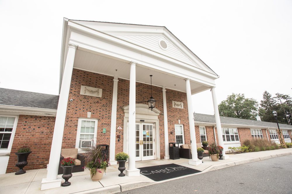 A traditional brick building entrance with white columns and a classical architectural style.