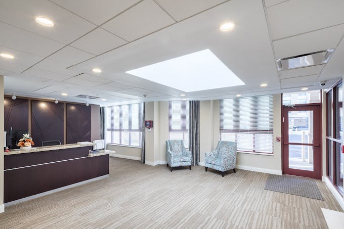 A spacious and well-lit office lobby with a reception desk and seating area.
