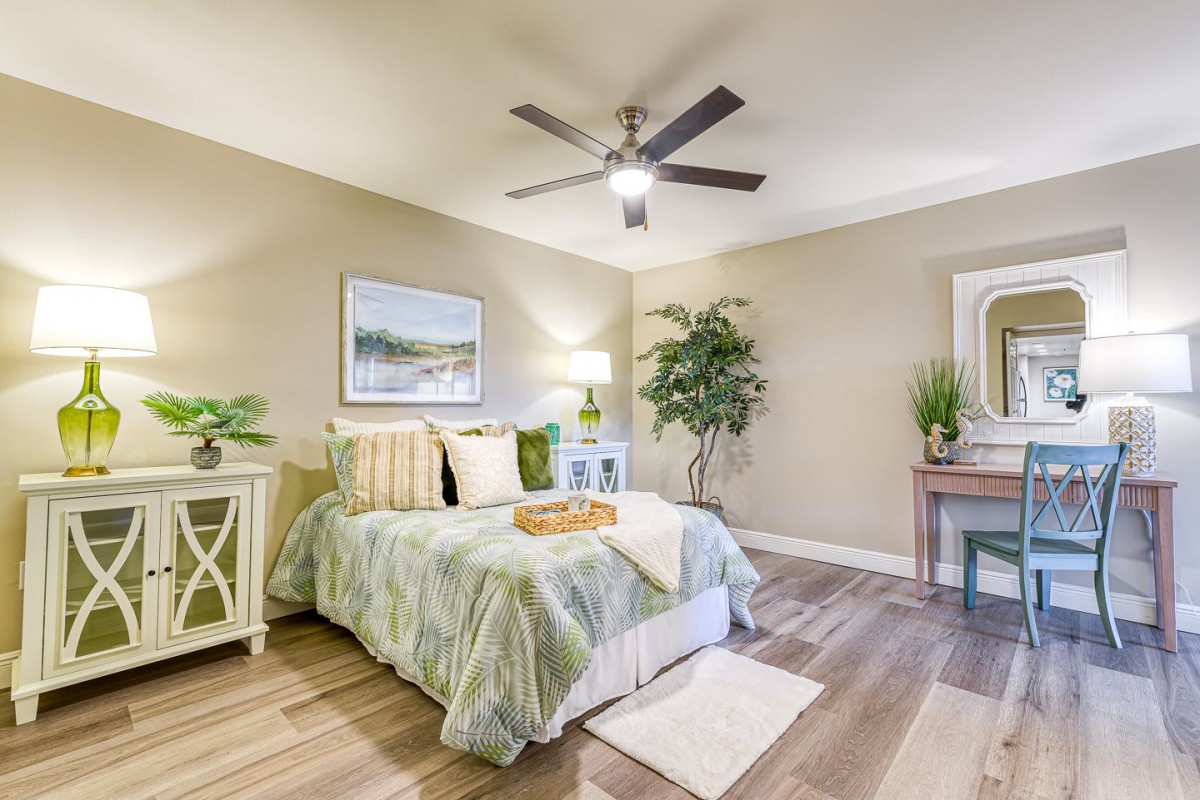 A stylish bedroom with elegant decor, featuring a comfortable bed, indoor plants, and tasteful artwork on the walls.