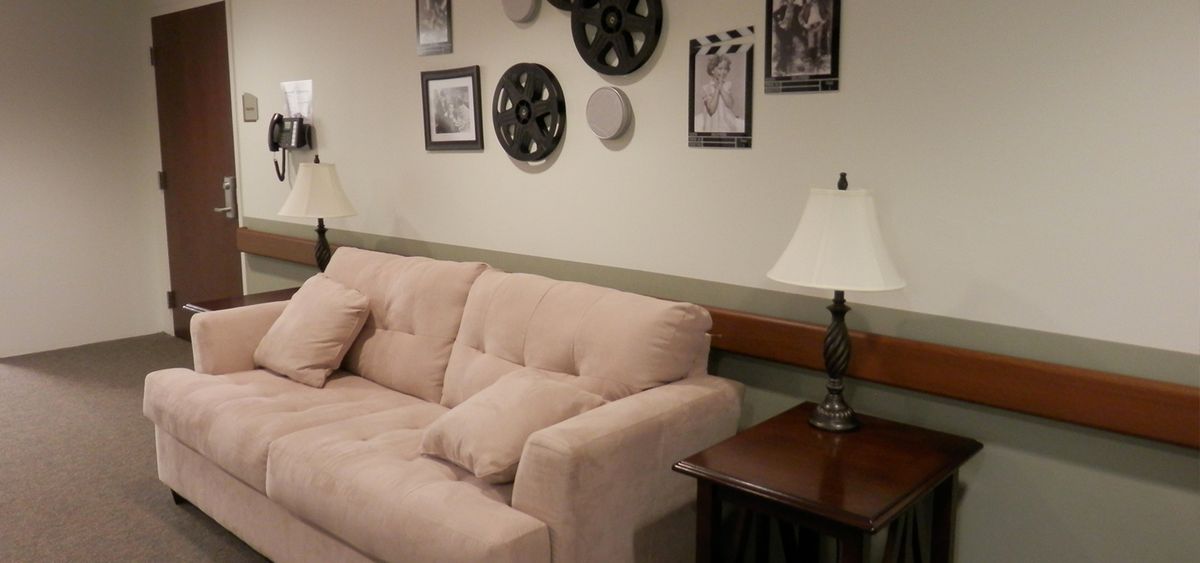 A cozy living room with a plush sofa, decorative wall art, and ambient lighting.