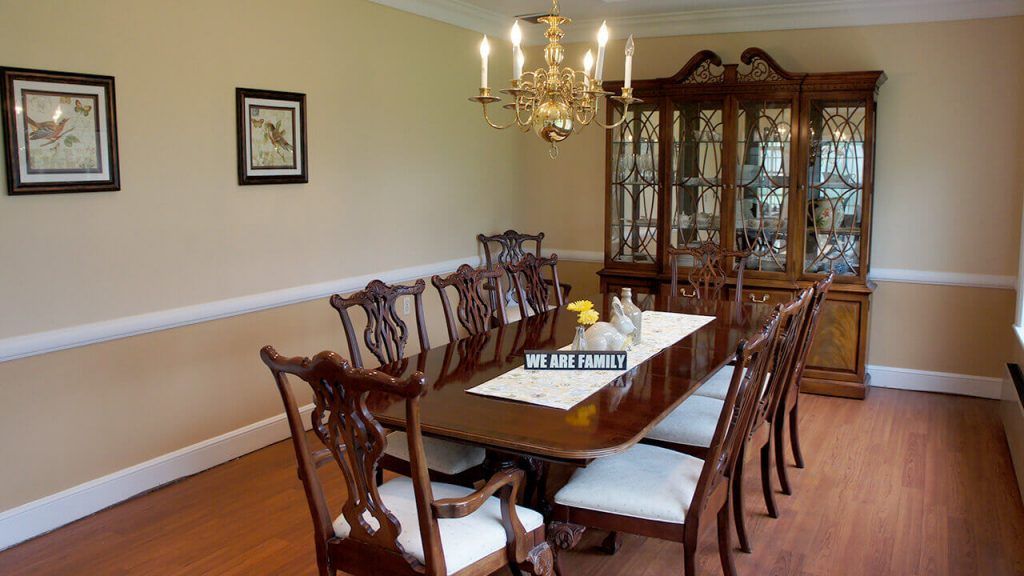 Elegantly furnished dining room with a large table and chandelier.