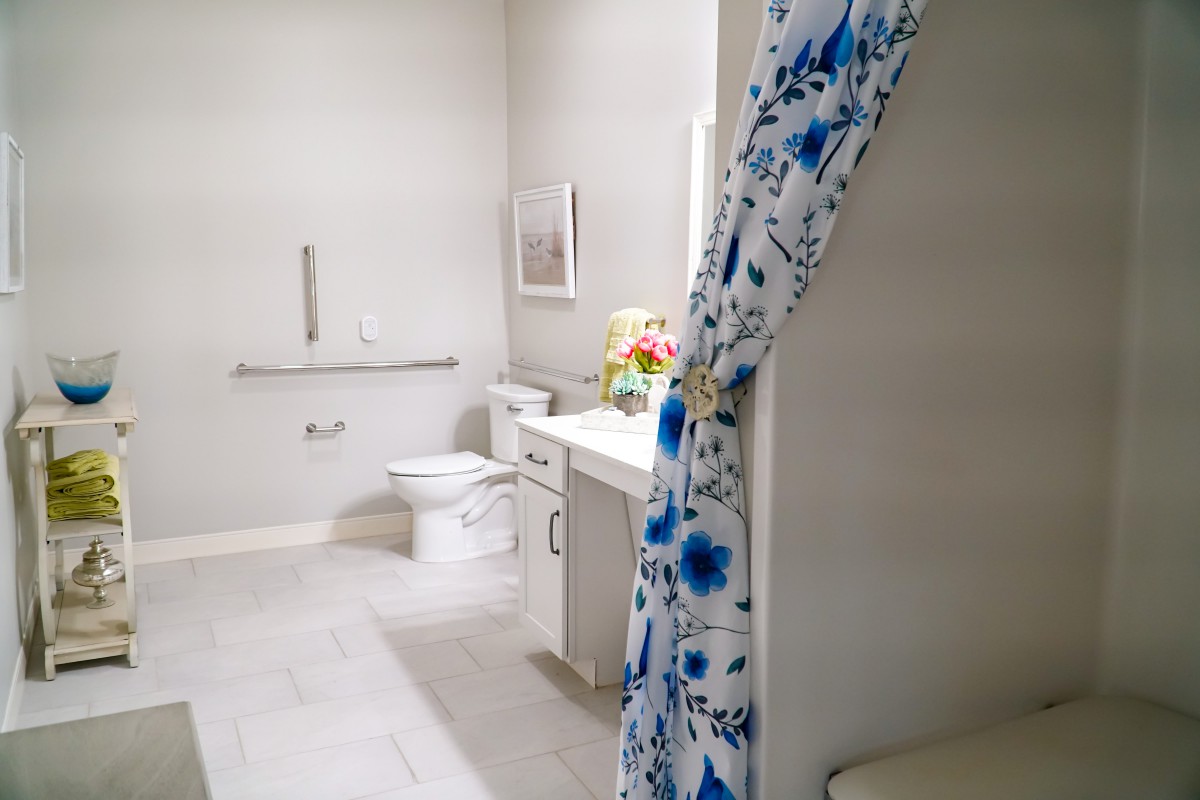 A modern bathroom with a floral shower curtain and clean white decor.