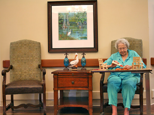 An elderly woman engaged in a leisure activity in a cozy indoor setting.