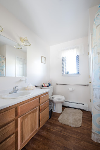 A well-lit and neatly organized bathroom featuring a vanity, toilet, and shower.