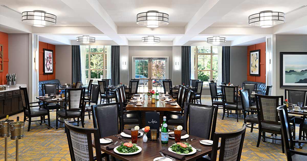 A modern and elegant dining room setup with multiple tables and chairs, ready for guests.