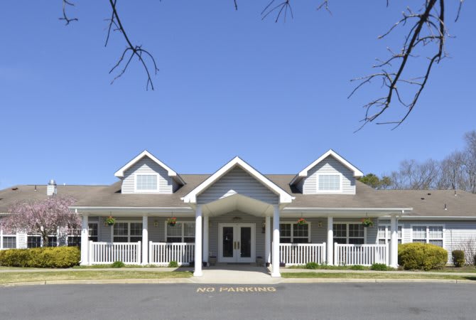 A front view of a residential building with a symmetrical design under a clear blue sky.