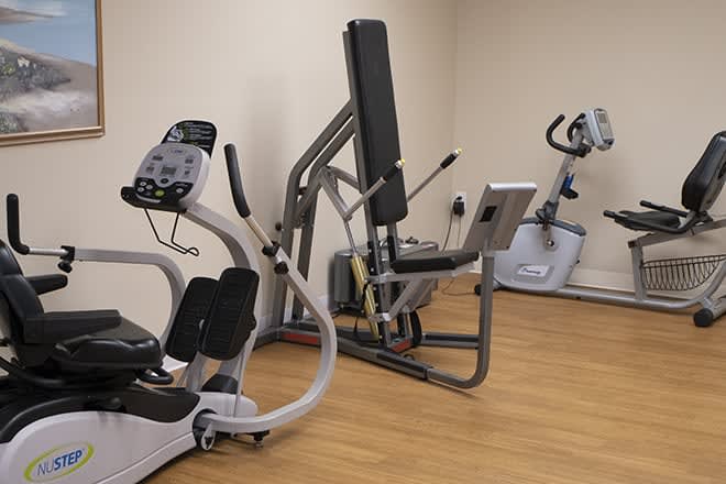 A small gym room with various exercise machines for fitness activities.