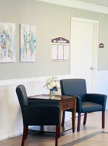 A cozy waiting room featuring modern artwork and comfortable seating.