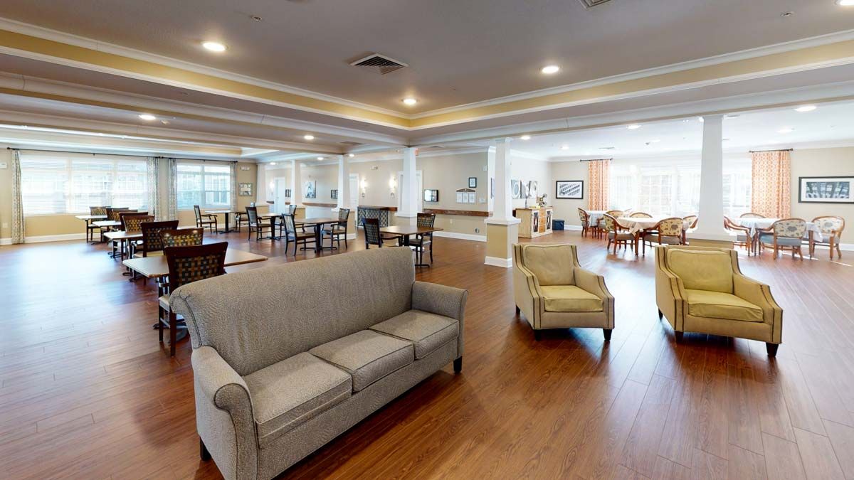 A spacious living area with modern furniture and wooden flooring.