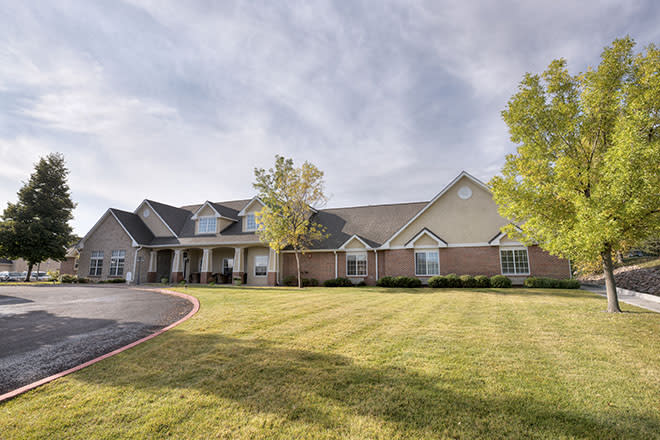 A large suburban house with a well-maintained lawn and driveway.
