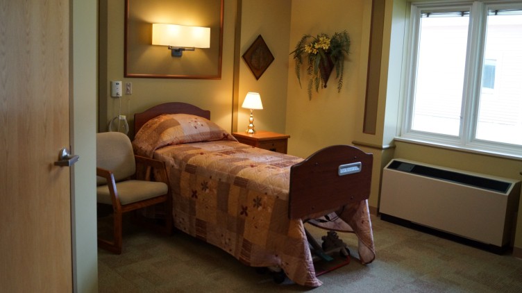A cozy and well-lit hospital room with a single bed and decorative elements.