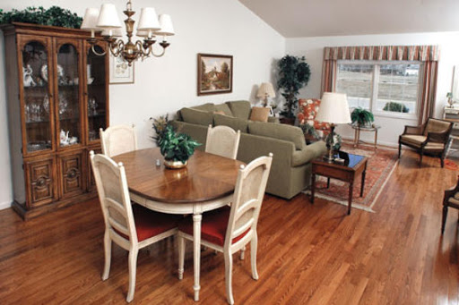 A cozy living and dining space featuring a wooden table, comfortable sofa, and decorative plants.