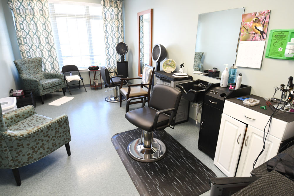 An interior view of a hair salon with styling chairs, mirrors, and equipment.
