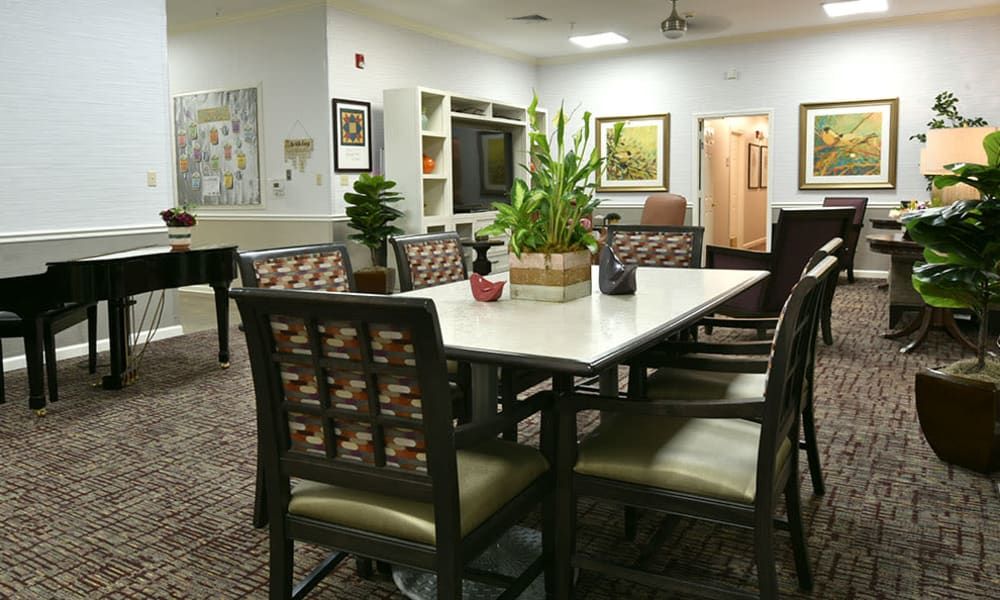 A cozy indoor living area with a table, chairs, and decorative plants.